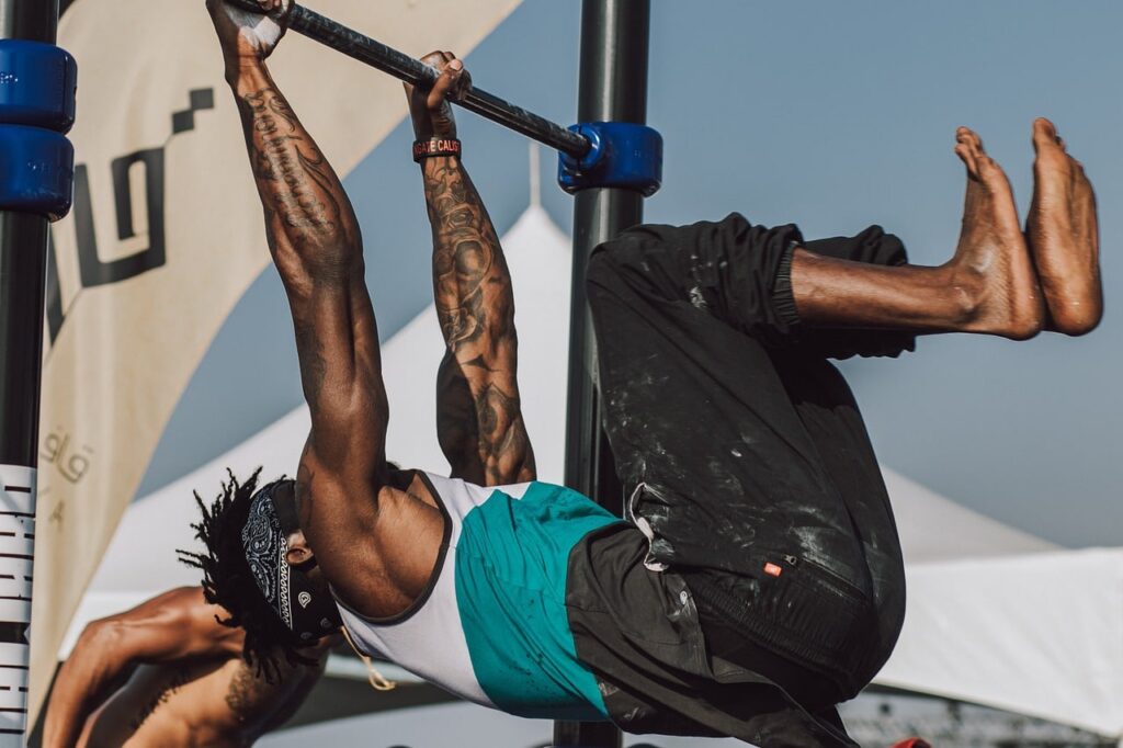 Muž cvičící na hrazdě.