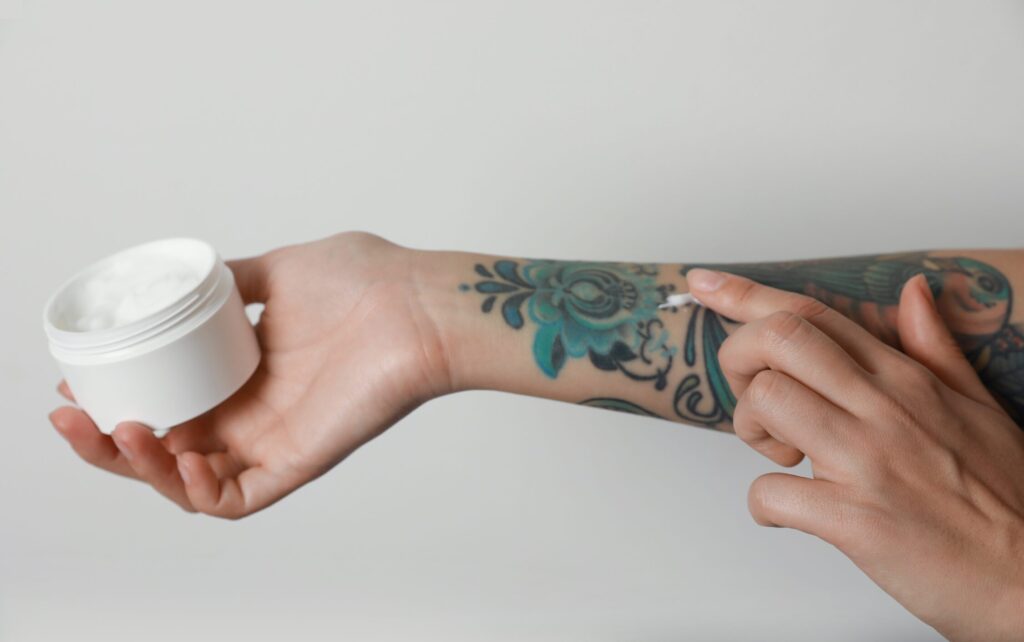 Dívka si maže nové tetování krémem.