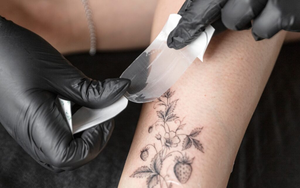 Lepení fólie přes nové tetování.