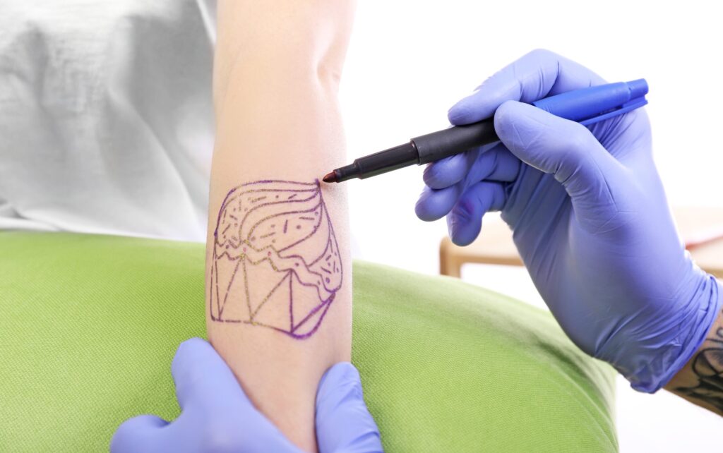 Kreslení tetovacího návrhu přímo na kůži.