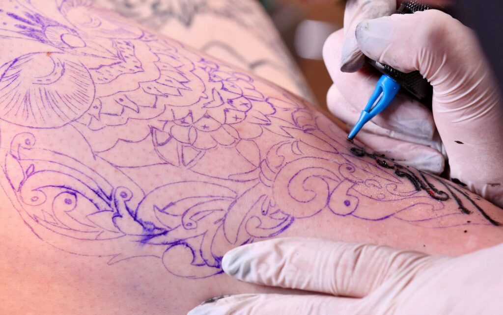 Proces tetování na kůži.