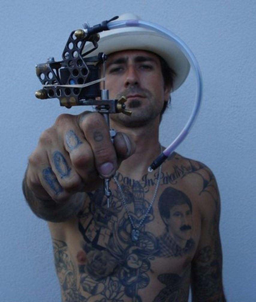 Tatér se svým tetovacím strojkem.