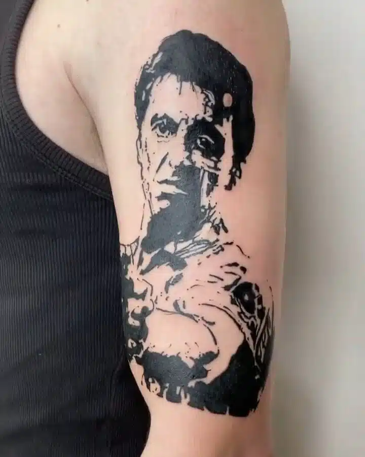 Tetování portrét osobnosti Tony Montana, symbol hudba na rameno