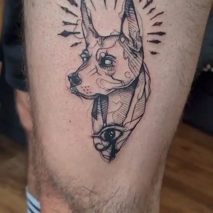 Tetování egyptské oko a Anubis na stehnu