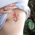 Tetování růžové lilie na boku.