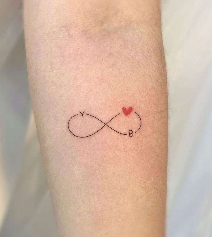 Tetování symbolu nekonečna v kombinaci s písmeny a srdcem.