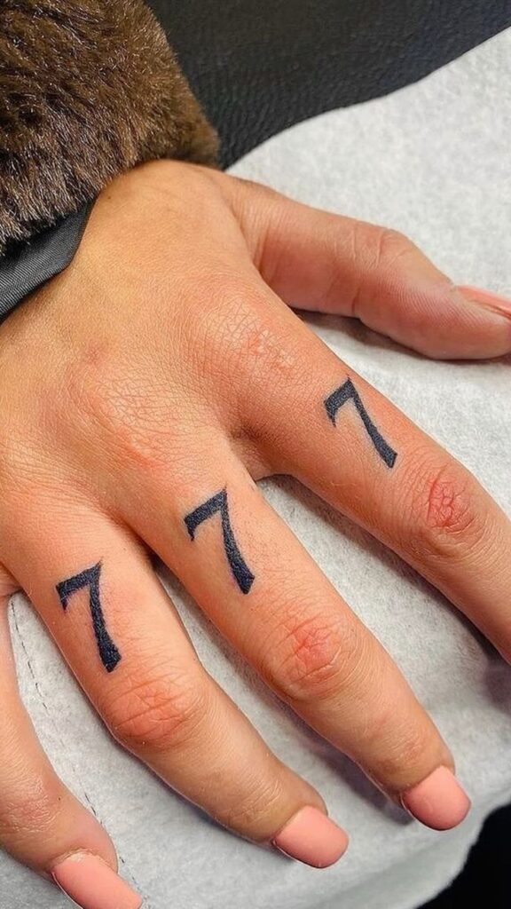 Tetování tří sedmiček na prstech.