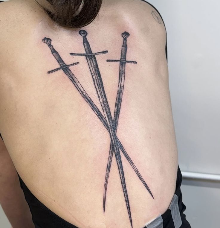 Tři zkřížené meče na zádech.