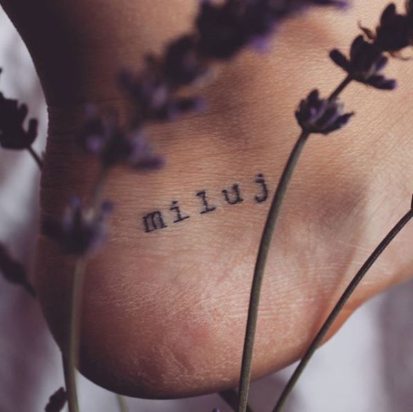 Nápis miluj na patě u nohy.