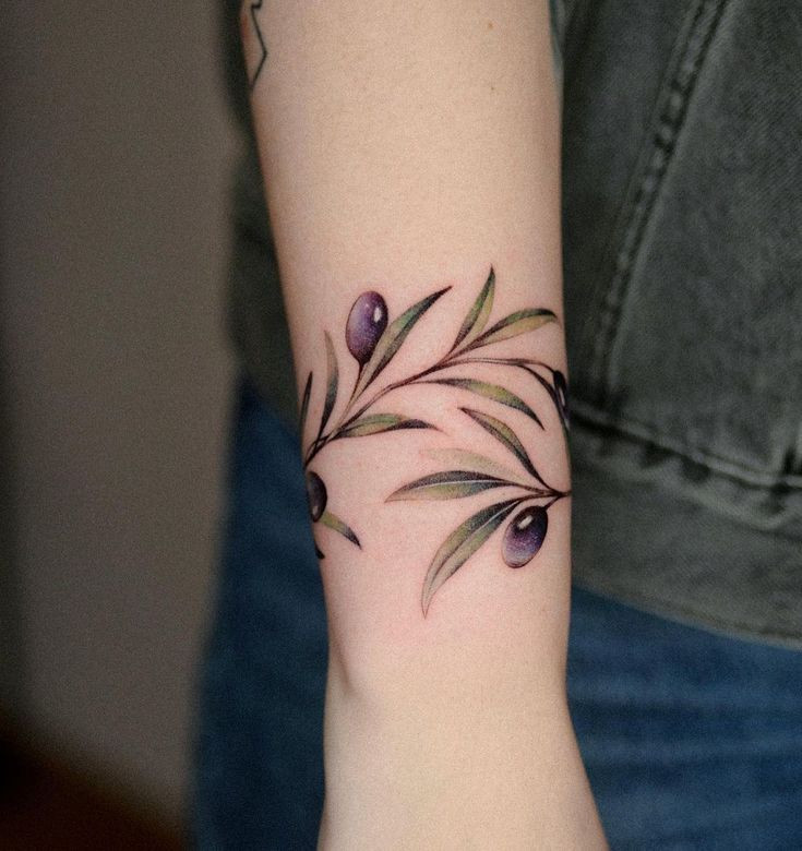 Olivová větvička s olivami kolem zápěstí.