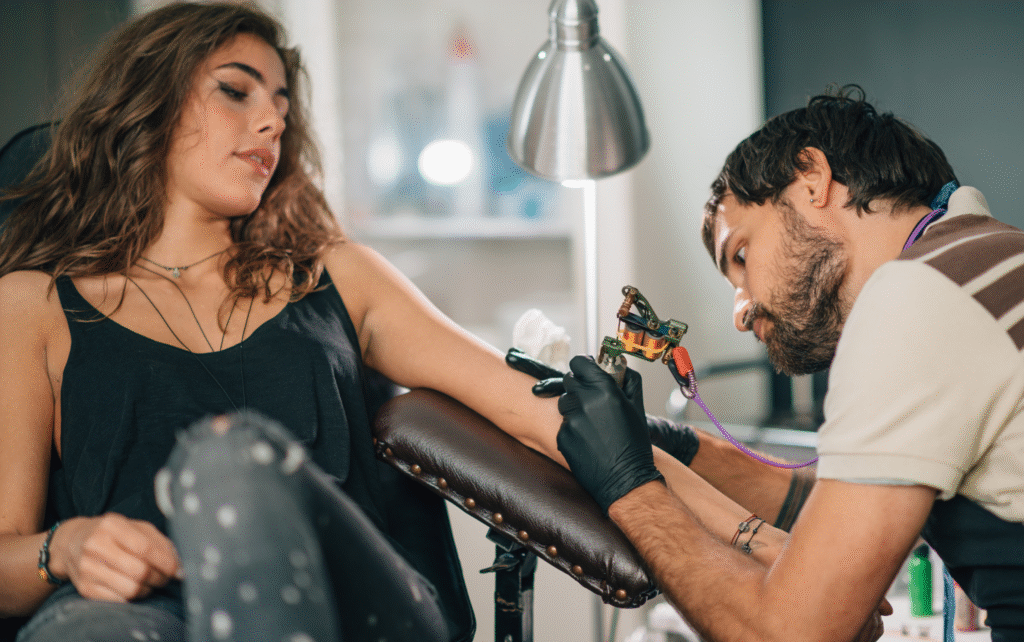 Tatér pracující na tetování předloktí.