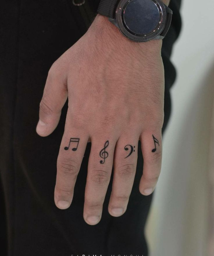 Potetované prsty hudebními znaky.