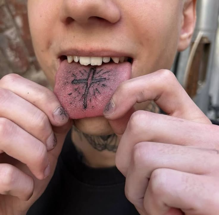 Tetování kříže na jazyku.
